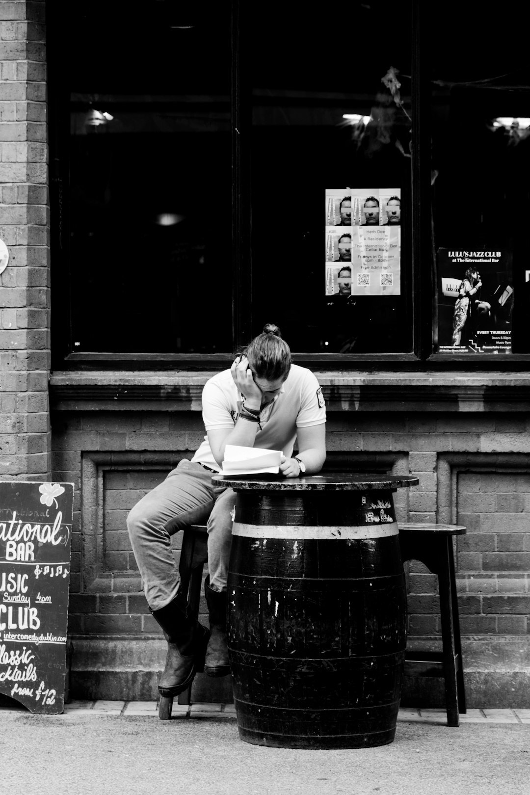 Man reading a newspaper at a cafe table