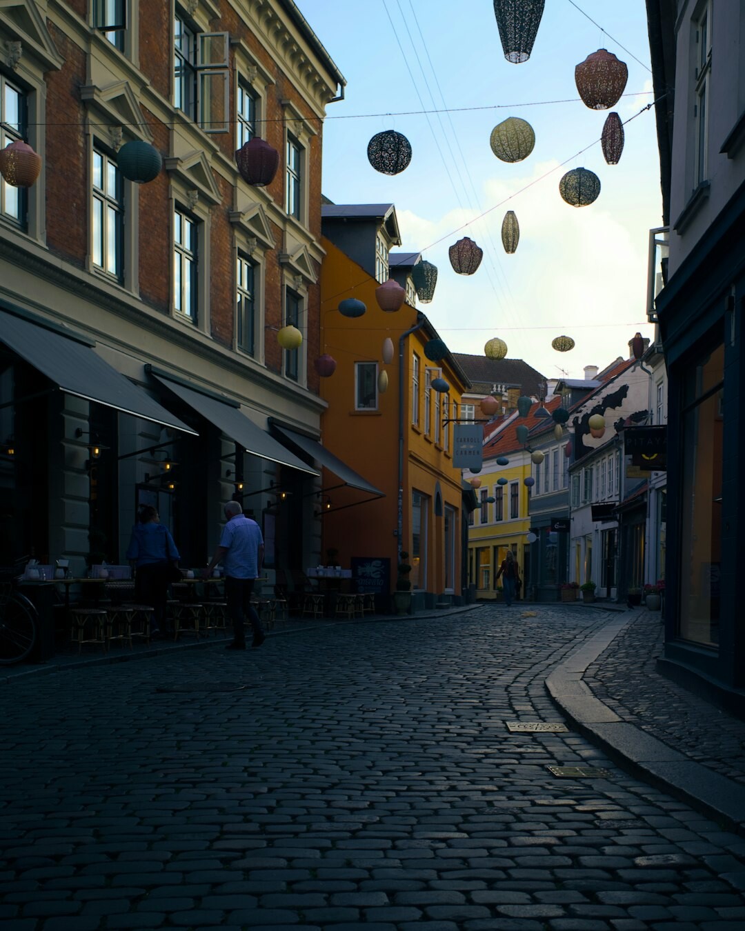 Pedestrians walking down a narrow street in Aarhus