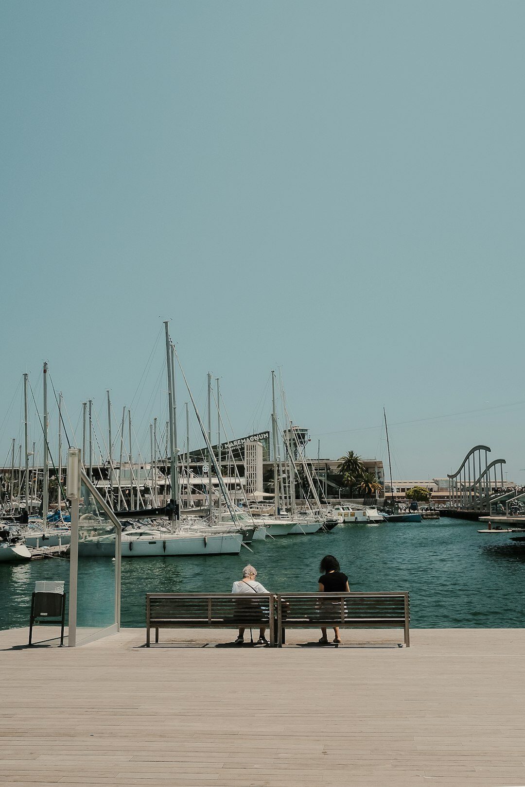 Elderly couple sitting on a bench by the harbour